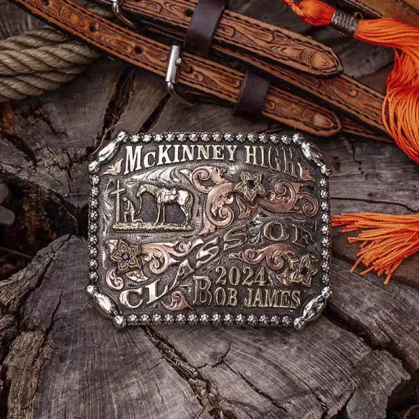 A custom western belt buckle for McKinney High Class of 2024 with personalized name featuring a praying cowboy figure 